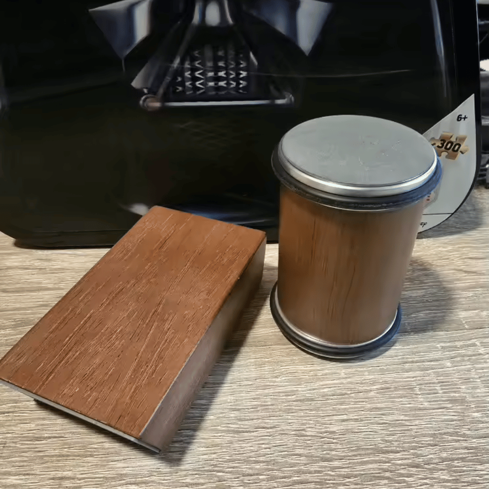 Wooden coaster and cylindrical wooden object on a textured surface with a blurred background