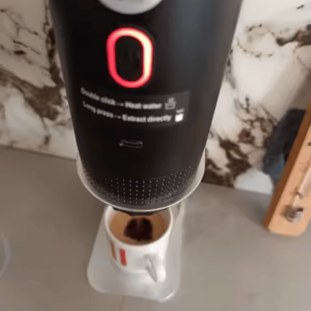 Black coffee maker with digital display on a marble countertop
