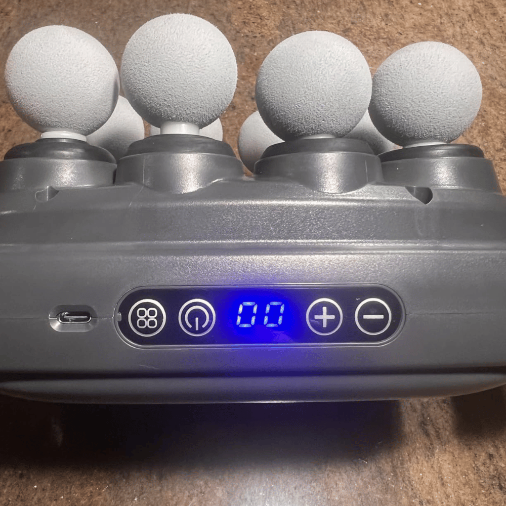 Close-up of a gray electronic device with foam handles on a brown surface